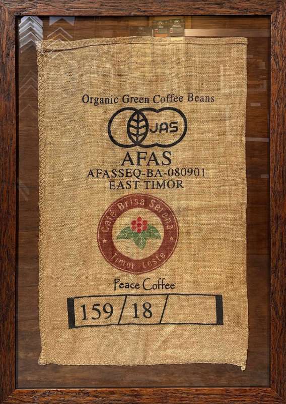 Burlap bag with coffee bean label on a wooden background
